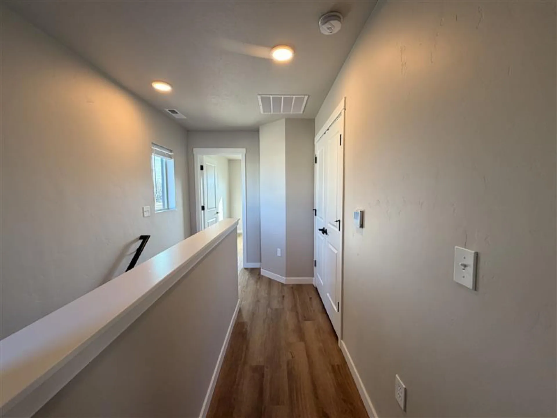 Upstairs hallway and landing with natural light in a two-story Eagle Villa townhome
