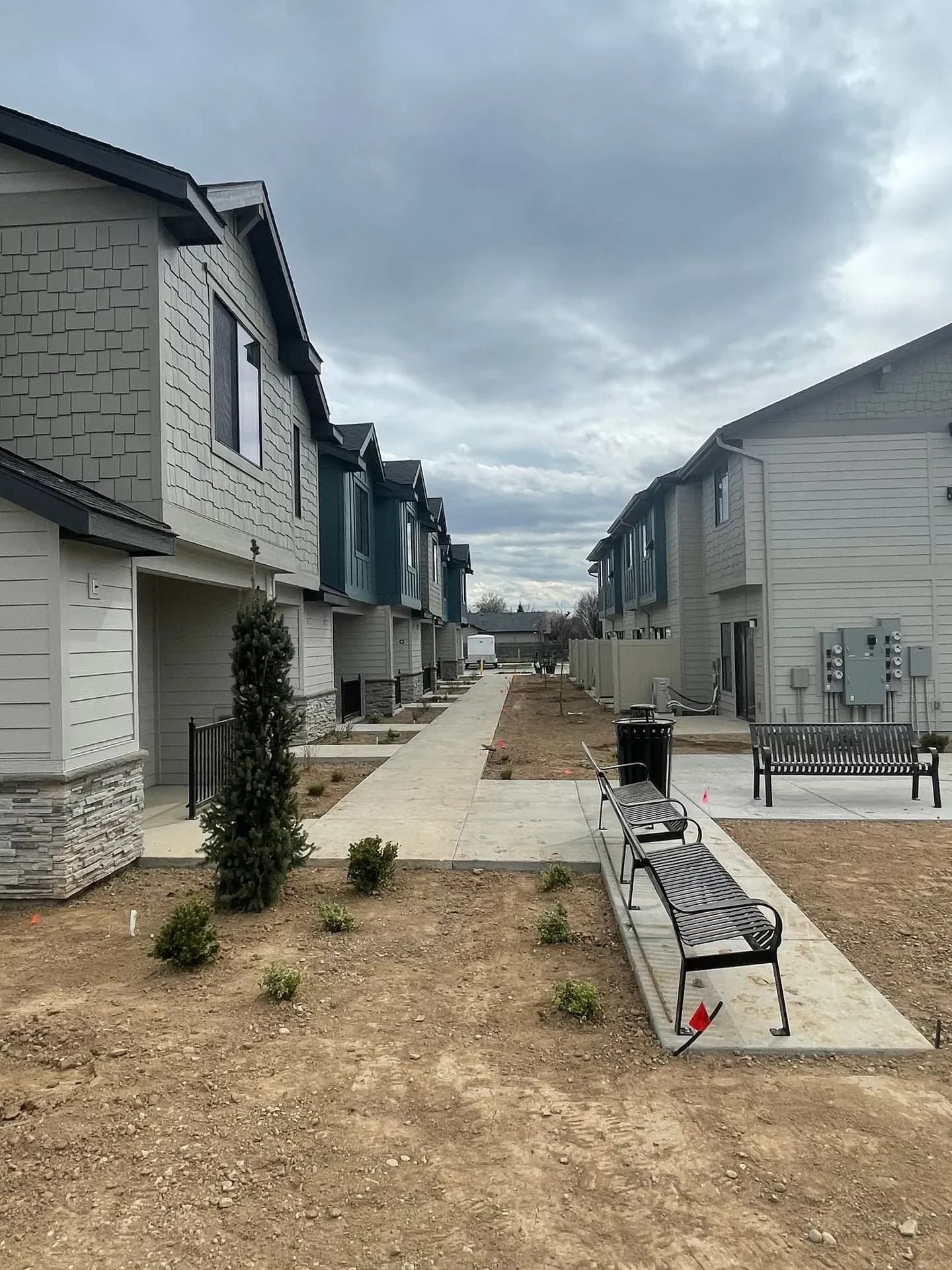 Pedestrian walkway with bench seating between townhome buildings at Eagle Villa in Boise